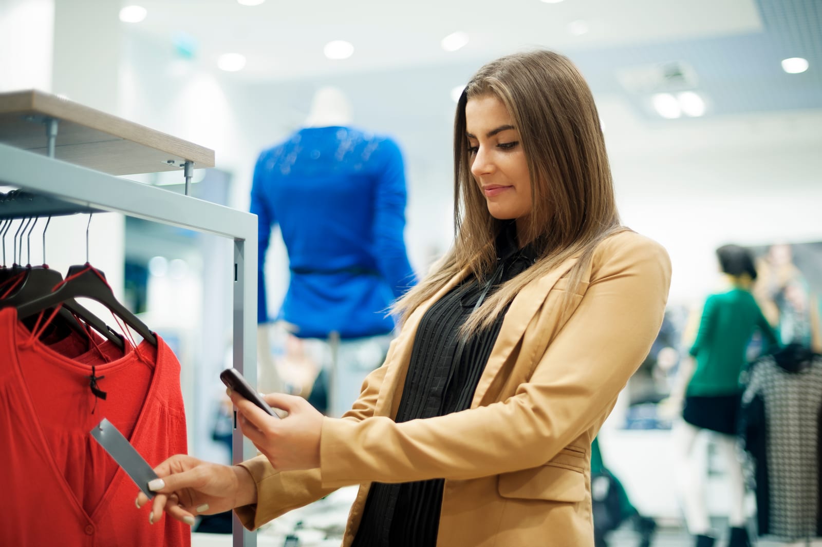 Una mujer comprueba con su móvil el código de barras y el precio de un producto en un centro comercial